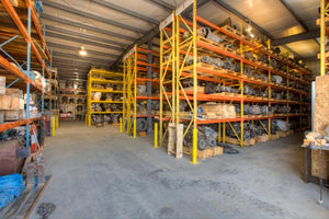 Engines and transmissions stored in shelves at an auto recycler. 