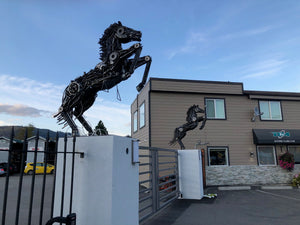 Horses made from auto parts on gate pillars at an auto recycler in lumby british columbia